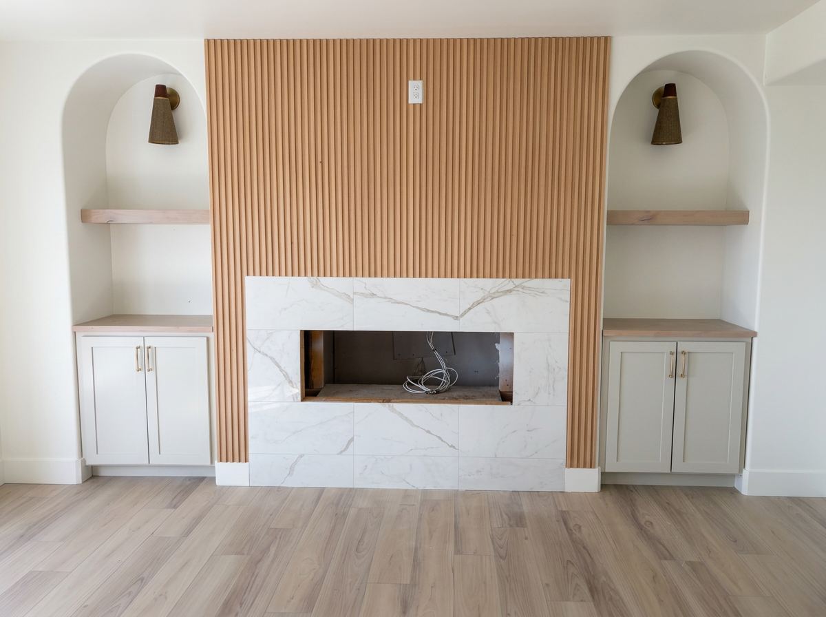 Custom wood-slat fireplace wall with symmetrical arched niches and brass sconces