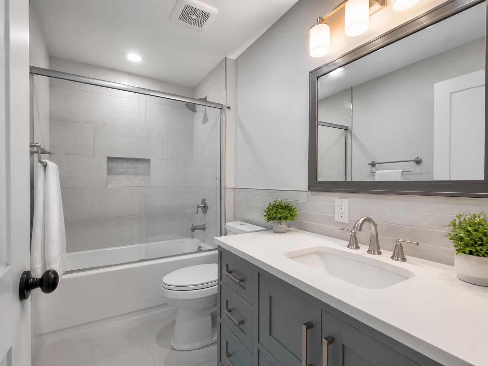 Finished guest bathroom with vanity light bar and GFCI receptacle